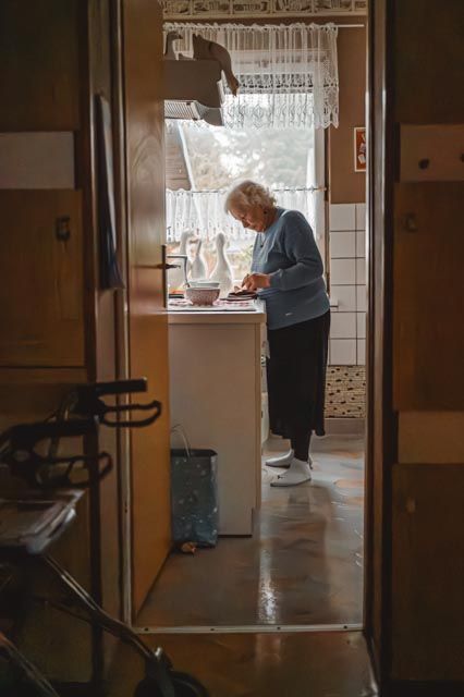 Ältere Frau am Küchenfenster