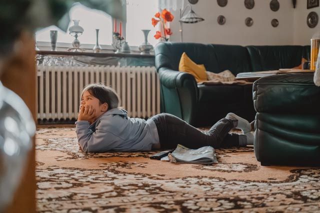 Mama und Kind lesen auf dem Boden